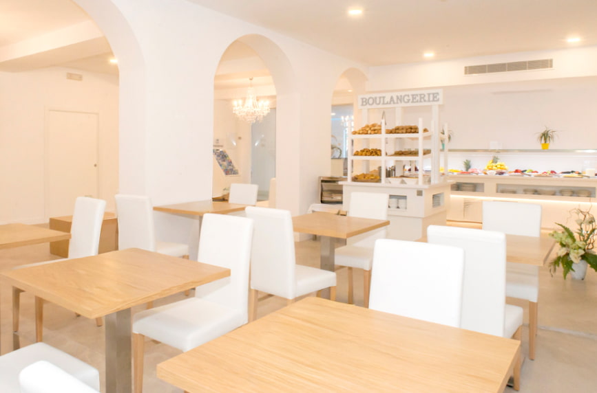 Zona de Desayuno Zona de Desayuno del Hotel Playas de Paguera, con modernas mesas de madera y sillas blancas